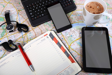 Praca w biurze, tablet, telefon, mapa, terminarz, planowanie podróży.