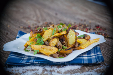 fried potatoes with mushrooms on a wooden background