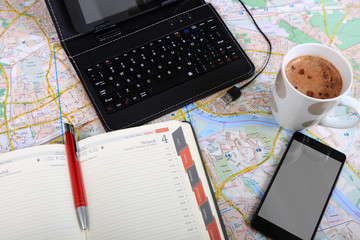 Praca w biurze, tablet, klawiatura, terminarz, telefon i kawa na mapie.