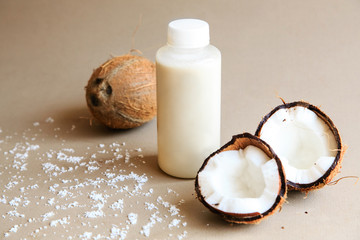 Coconuts and a jar of coconut milk on background. Cut tasty coconuts and a bottle full of delicious fresh milk. Beautiful nutritious nuts.