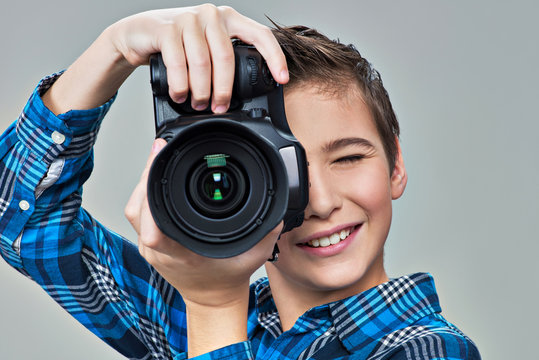 Boy with photo camera looks in the viewfinder