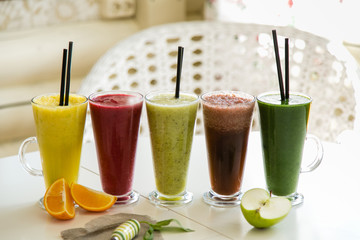 Different smoothie set on a white concrete background