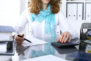 Female bookkeeper or financial inspector  making report, calculating or checking balance. Internal Revenue Service checking financial document. Audit concept