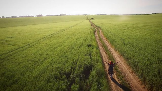 4K Aerial Free Girl Walking in Fields with Hands Raised