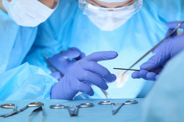 Close-up of medical team performing operation. Group of surgeons at work are busy of patient. Medicine, veterinary or healthcare and emergency in hospital