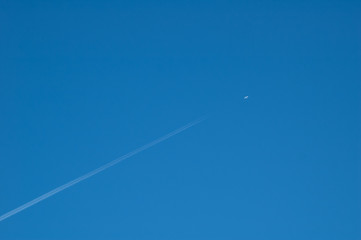 background image - vapor trail from large jet against deep blue sky
