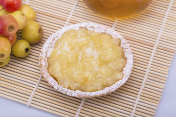 Still life. Cake with apple jam, bunches of small apples on a white background