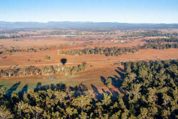 Fototapeta premium The shadow of a hot air balloon travels over the vast outback countryside.
