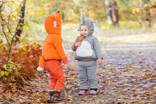 Little Children In Animal Costumes Playing In Autumn Forest