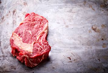 Raw Fresh Marbled Meat Beef Steak on the Gray Metal Background  Top View Copy space for Text