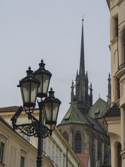 close up old street lamp in Brno historical city center with towers of gothic cathedral in czech republic