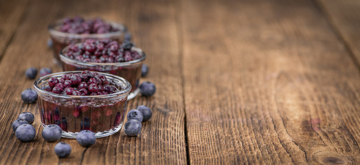 Portion of Blueberries (preserved) on wooden background, selective focus