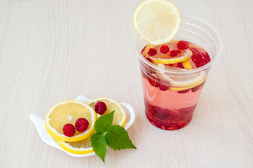 Lemon slices, drink, berries and raspberry leaves