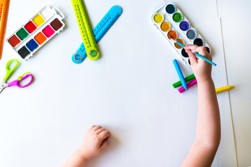 The child holds the brush over the palette