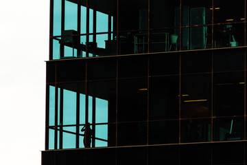 Silhouette of a woman talking on the phone in an office building