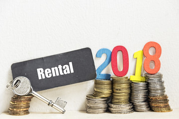 Key and coin with the word RENTAL and Number 2018 - the concept of savings