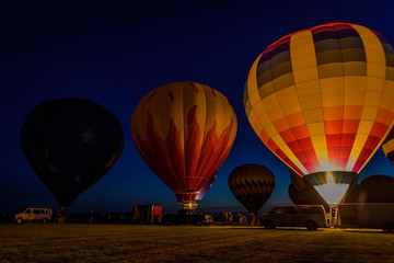 hot air balloons glowing in night sky