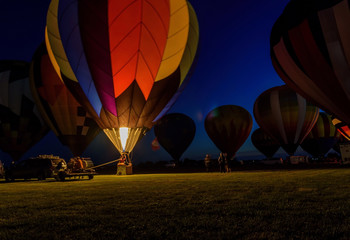 hot air balloons glowing in night sky