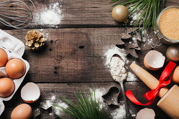 Xmas baking or cooking background. Ingredients, kitchen items for baking cookies. Kitchen utensils, flour, eggs, sugar and milk. Text space, top view.
