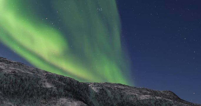 Northern Lights, polar light or Aurora Borealis in the night sky time lapse over Senja island in Northern Norway.