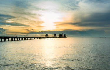 Fototapeta na wymiar The long bridge over the sea with a beautiful sunrise.