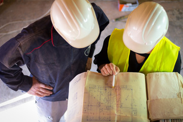 A female engineer shows the building project to the head of the building site