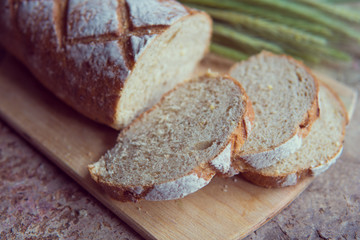 Bread slice on a wooden board. Wheat fresh loaf