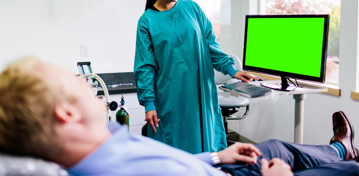 Man In Dentist Chair Talking With Doctor With Green Screen