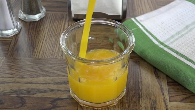 Pouring fresh orange juice into a glass
