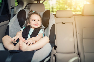 Infant baby girl buckled into her car seat. © REDPIXEL