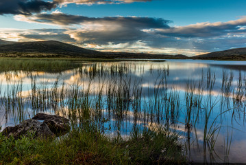 Clouds reflecting on a Norwegian lake at sunset in the Rondane National Park in Norway