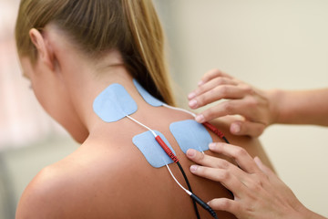 Electro stimulation in physical therapy to a young woman - obrazy, fototapety, plakaty