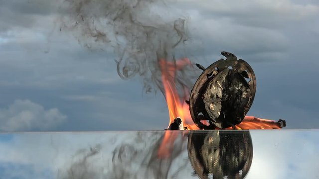 End burning old analoge clock on mirror on sky background, time concept