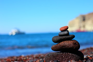 Fototapeta na wymiar Pila di pietre sulla spiaggia di Santorini
