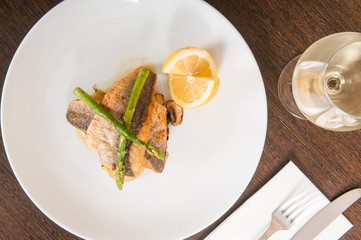 gourmet seafood dish of fish and asparagus on a white plate