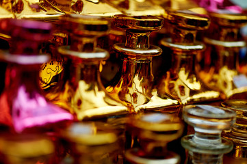 Glass perfume bottles based oils. A Bazaar, market. Macro. Gold and pink gamma