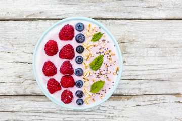 A bowl of healthy and delicious smoothie with grains and fresh berry fruit. 