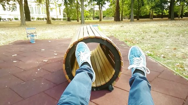 young man enjoying with swing in the beautiful sunny day playing in the playground, seesaw funny in the sunlight with friends concept
