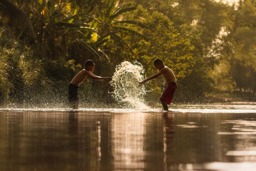 rural chaidren playing water in the river.