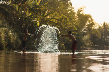 rural chaidren playing water in the river.