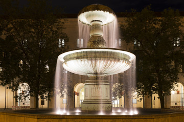 Beleuchteter Brunnen am Geschwister-Scholl-Platz in München