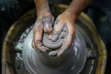 Man potter making ceramic pot on the pottery wheel
