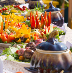  Table with homemade food decorated in Russian folk style.Baked and fresh vegetables in a bowl on a festively decorated table.