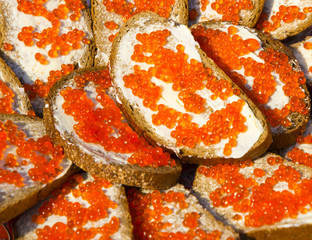 Sandwiches with butter and red caviar. Caviar on black bread. Sandwiches with caviar of salmon fish species.