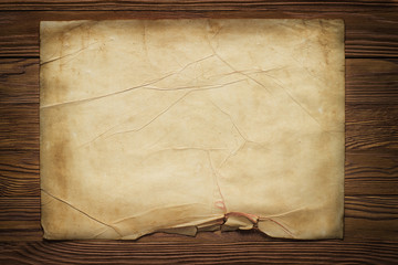 old broken horizontal sheet of paper on brown wooden board