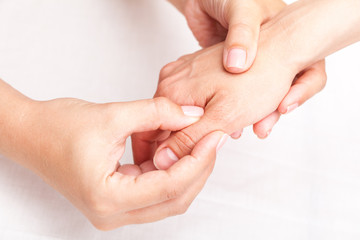 Woman receiving osteopathic treatment of her thumb