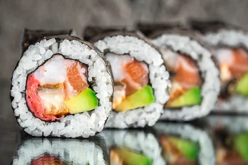 Selbstklebende Fototapeten Sushi-Rolle mit Lachs, Garnelen und Avocado © Vankad