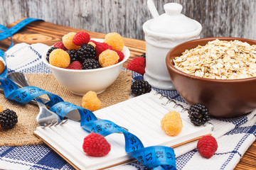 Portion of oatmeal in the bowl with raspberries and measuring tape