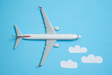 white airplane on a blue background with clouds