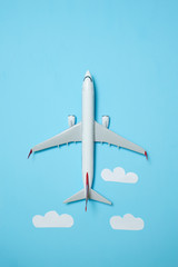 white airplane on a blue background with clouds